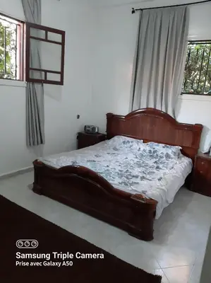 a bedroom with a wooden bed in a room at إقامة علياء in Marrakech