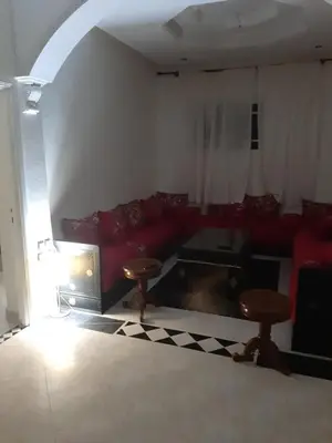 a living room with a red couch and two stools at إقامة علياء in Marrakech
