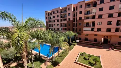 an apartment with a pool in front of a building at résidence assafa central H26 in Marrakech