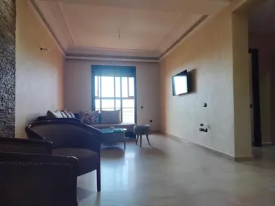 a living room with a couch and a table at résidence assafa central H26 in Marrakech