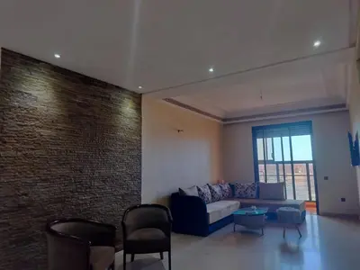 a living room with a couch and a brick wall at résidence assafa central H26 in Marrakech