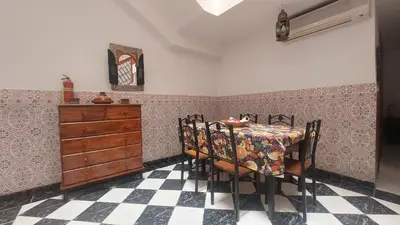 a dining room with a table and chairs and a dresser at Agréable maison familiale in Marrakech