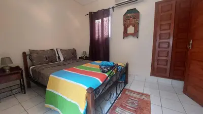 a bedroom with a bed and a window and a door at Agréable maison familiale in Marrakech