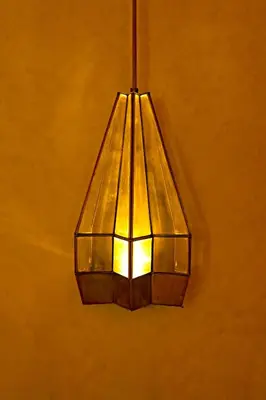 a lamp hanging from a wall with a light at Riad Romeo in Marrakech