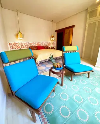 a bedroom with two chairs and a bed and a table at Riad Romeo in Marrakech