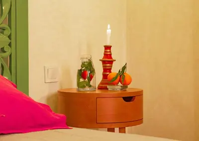 a candle on a table next to a bed at Riad Romeo in Marrakech