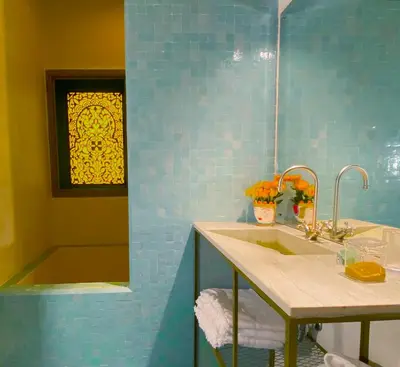 a bathroom with a sink and a shower and a mirror at Riad Romeo in Marrakech