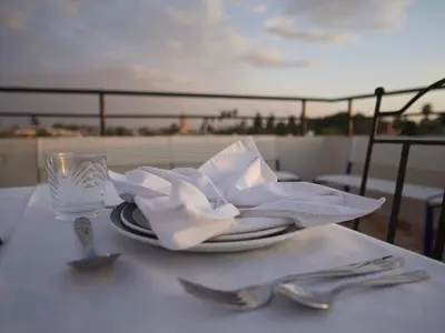 a table with a plate with a napkin and a glass at Riad Ocallaghan in Marrakech
