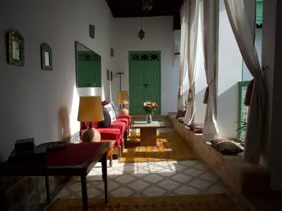 a living room with green doors and red couches at Riad Ocallaghan in Marrakech