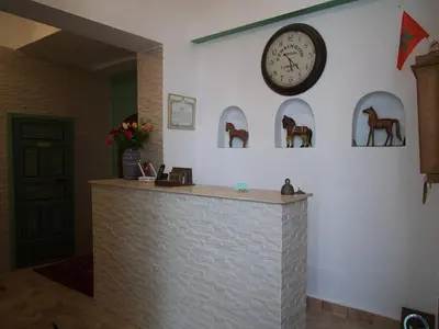 a counter with a clock on the wall and statues of horses at Riad Ocallaghan in Marrakech