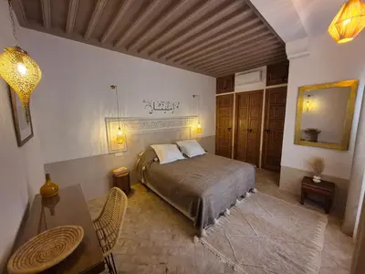 a bedroom with a bed and a table in it at Riad Casa Dolce Marrakech Médina in Marrakech