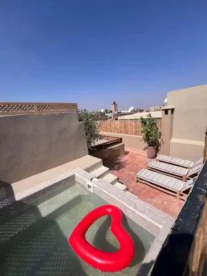 a swimming pool with a red object in the water at Riad Casa Dolce Marrakech Médina in Marrakech