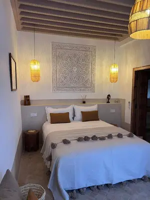 a bedroom with a large white bed with flowers on it at Riad Casa Dolce Marrakech Médina in Marrakech