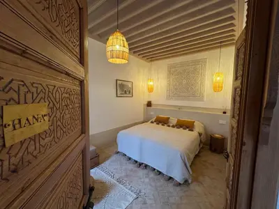 a bedroom with a bed and a chandelier at Riad Casa Dolce Marrakech Médina in Marrakech