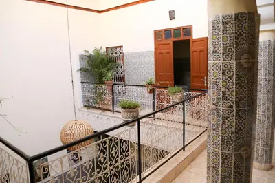 a balcony with a railing with potted plants on it at Riad Fridi in Marrakech