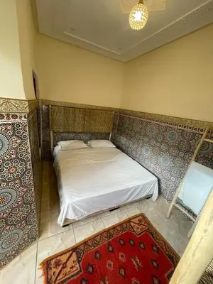 a bedroom with a bed and a rug at Riad Fridi in Marrakech