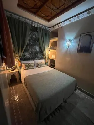 a bedroom with a bed with a light on the wall at Riad Amazing Amazigh avec jacuzzi petit déjeuner compris avec aussi chambres familiales près de la place jemaa El fna in Marrakech