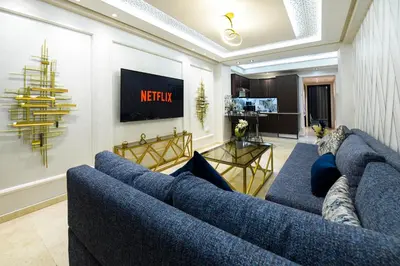 a living room with a blue couch and a television at E-Appartement de luxe centre Gueliz piscine parking fibre netflix in Marrakech