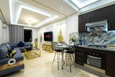 a kitchen and living room with a couch and a table at E-Appartement de luxe centre Gueliz piscine parking fibre netflix in Marrakech