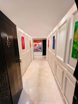 a hallway with paintings on the walls and a door at E-Appartement de luxe centre Gueliz piscine parking fibre netflix in Marrakech