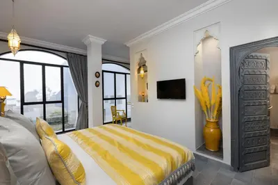 a bedroom with a bed with a yellow blanket on it at Riad Sybil Boutique Hotel in Marrakech