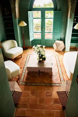 a living room with a table with a vase of flowers at Villa Prestige Mansourya in Marrakech
