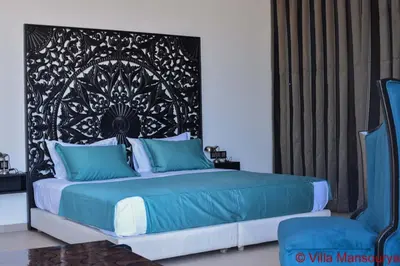 a bedroom with a bed with a black and white headboard at Villa Prestige Mansourya in Marrakech