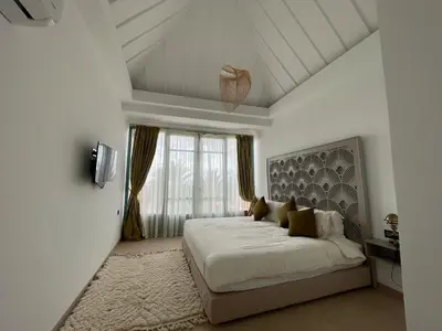 a white bedroom with a bed and a window at Villa Prestige Mansourya in Marrakech