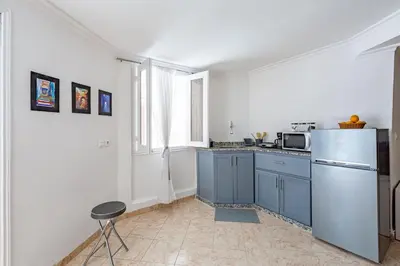 a kitchen with blue cabinets and a refrigerator at Cosy apartment in the heart of Hivernage in Marrakech