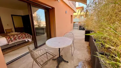 a patio with a table and chairs on a balcony at Appartement de luxe a Care Eden in Marrakech