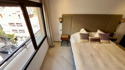 a bedroom with a bed and a large window at Appartement de luxe a Care Eden in Marrakech