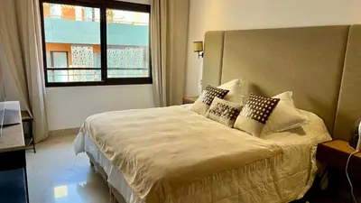 a bedroom with a bed with pillows and a window at Appartement de luxe a Care Eden in Marrakech