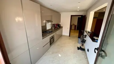 a kitchen with white cabinets and a counter top at Appartement de luxe a Care Eden in Marrakech