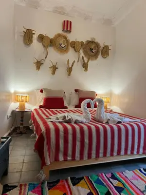 a bedroom with a bed with two swans on it at Riad EL BADI in Marrakech