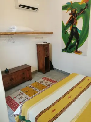 a bedroom with a bed and a painting on the wall at Riad EL BADI in Marrakech