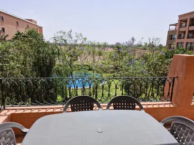 a white table and chairs on a balcony at Appartement babylon 2 marrakech in Marrakech