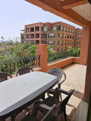 a table and chairs on a balcony with a building at Appartement babylon 2 marrakech in Marrakech