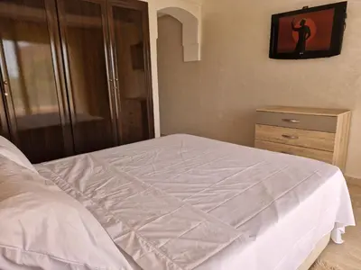 a bedroom with a white bed and a dresser at Appartement babylon 2 marrakech in Marrakech