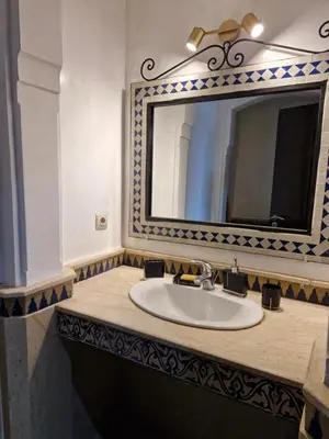 a bathroom with a sink and a mirror at Appartement babylon 2 marrakech in Marrakech