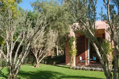 a house with a lawn and trees in front of it at Villa JENAMAN in Marrakech