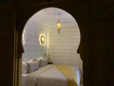 a bedroom with a bed with an arched doorway at Riad SunSet Marrakech in Marrakech