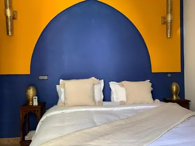 a bedroom with a large bed with a blue wall at Riad SunSet Marrakech in Marrakech