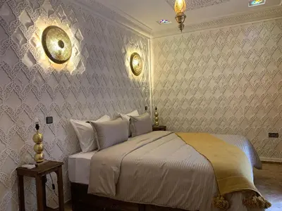 a bedroom with a bed and a wall at Riad SunSet Marrakech in Marrakech