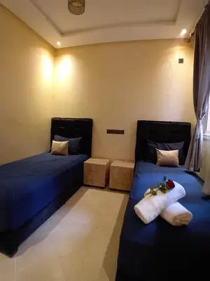 two beds in a room with towels on them at Beautiful Apartment Near Airport in Marrakech