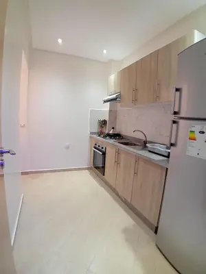 an empty kitchen with a refrigerator and a sink at Beautiful Apartment Near Airport in Marrakech