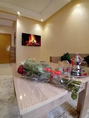 a table in a room with a fire in the background at Beautiful Apartment Near Airport in Marrakech