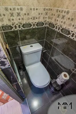 a bathroom with a white toilet in a tiled wall at MA Studio in Marrakech