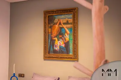 a painting hanging on a wall next to a bed at MA Studio in Marrakech