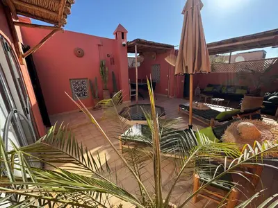 a patio with an umbrella and a couch at DarDabakech, proche Jemma el Fna, souk, riad, centre Medina - Maison entière de 2 à 6 personnes, possibilité 3 chambres in Marrakech