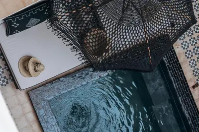 an umbrella sitting on top of a pool of water at Maison Dar Saada in Marrakech